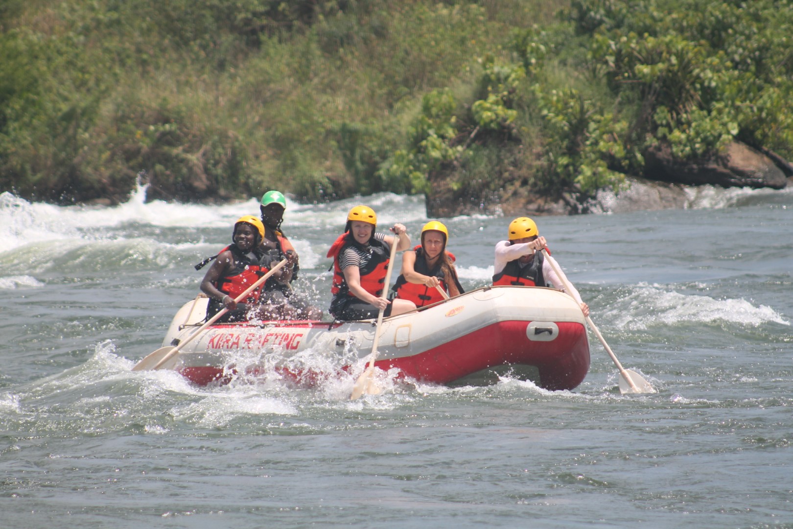 Kiira Rafting crew paddling hard through a Nile rapid